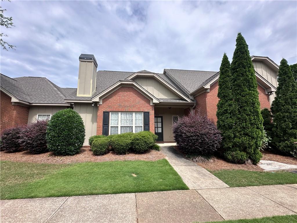 1630 Academy Dr Unit 404, Auburn, AL 36830 - view of front of home with brick siding, a chimney, and a front yard
