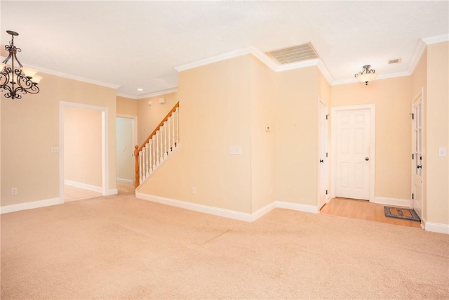 1630 Academy Dr Unit 404, Auburn, AL 36830 - empty room featuring light colored carpet, crown molding, stairway, and a chandelier