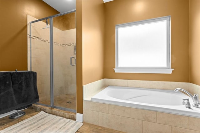 bathroom with hardwood / wood-style flooring and separate shower and tub