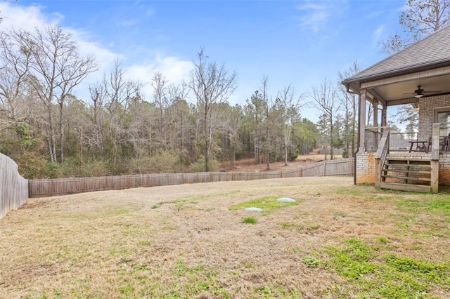 view of yard featuring a wooden deck and ceiling fan