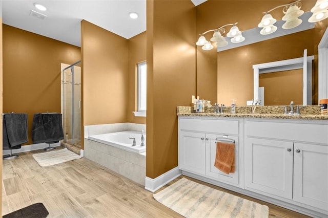 bathroom featuring vanity, wood-type flooring, and shower with separate bathtub