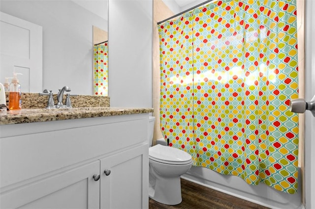 full bathroom with shower / tub combo, vanity, hardwood / wood-style flooring, and toilet