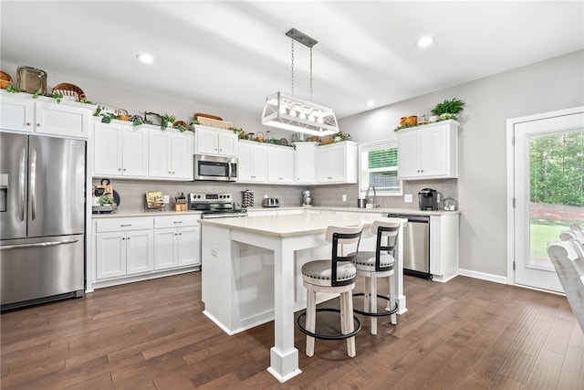 712 Mcdonald Dr, Opelika, AL 36801 - kitchen with white cabinets, dark wood finished floors, light countertops, appliances with stainless steel finishes, and decorative backsplash