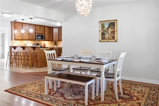 dining area featuring light wood-type flooring and a chandelier