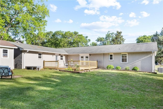 rear view of property with brick siding, a deck, a lawn, and central air condition unit