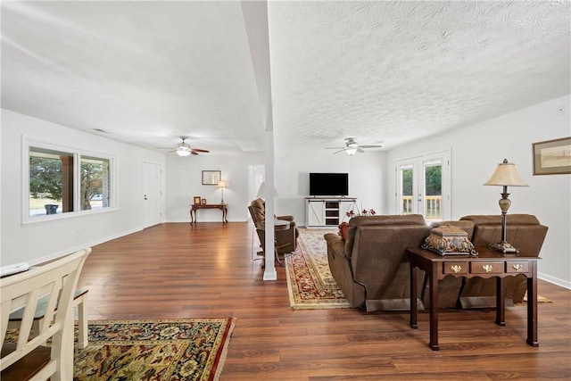 living area featuring french doors, ceiling fan, and dark wood-style floors
