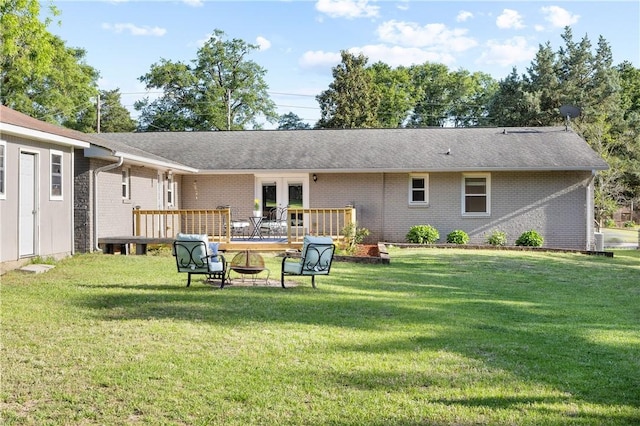 rear view of house featuring a wooden deck, a yard, and brick siding