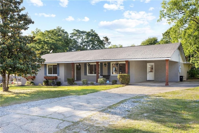 ranch-style house featuring concrete driveway, a front yard, an attached carport, and brick siding