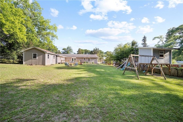 view of yard with a playground and an outbuilding