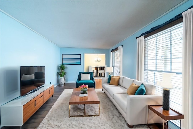 living area featuring baseboards, ornamental molding, and wood finished floors