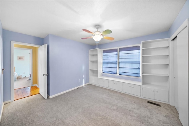 unfurnished bedroom featuring carpet, visible vents, ceiling fan, and baseboards