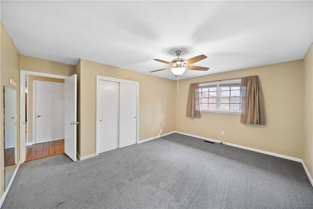 unfurnished bedroom with baseboards, visible vents, a ceiling fan, carpet, and a closet