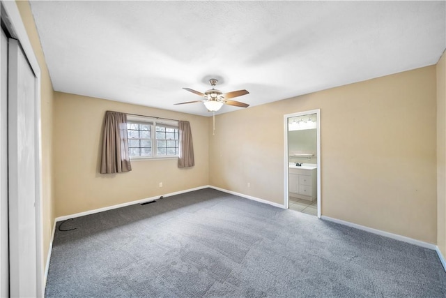 unfurnished bedroom with visible vents, baseboards, connected bathroom, carpet, and a closet