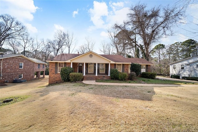 view of front facade featuring a porch, brick siding, crawl space, and a front yard