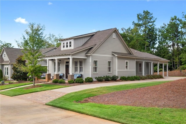 craftsman house featuring covered porch and a front lawn