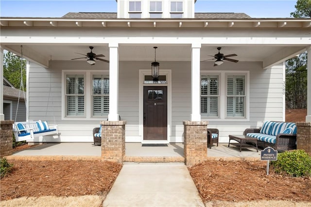 doorway to property with a porch and ceiling fan