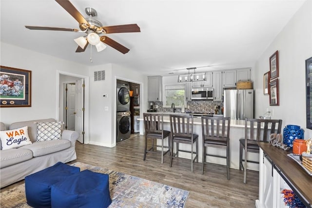528 Genelda Ave Unit 19, Auburn, AL 36832 - living room featuring estacked washer and dryer, a ceiling fan, dark wood-type flooring, and a chandelier