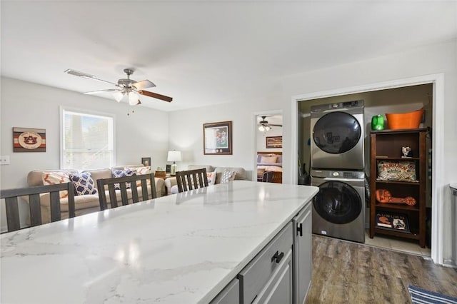 528 Genelda Ave Unit 19, Auburn, AL 36832 - laundry area with stacked washing machine and dryer, ceiling fan, and wood finished floors