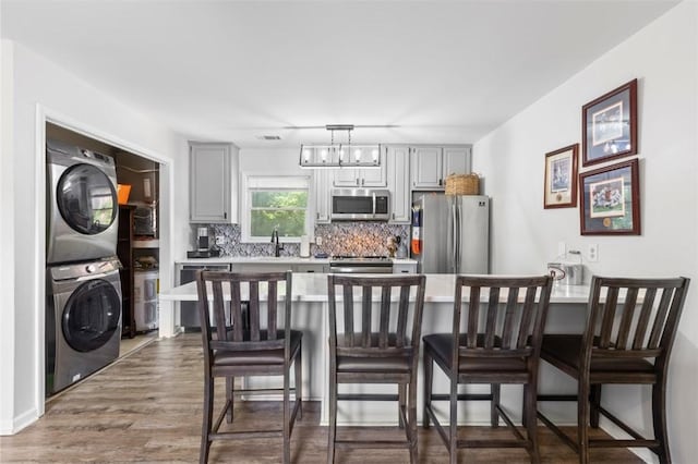 528 Genelda Ave Unit 19, Auburn, AL 36832 - kitchen featuring stainless steel appliances, stacked washer / drying machine, light countertops, and decorative backsplash
