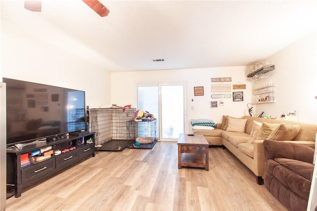 living area featuring bar area, light wood-style flooring, and visible vents