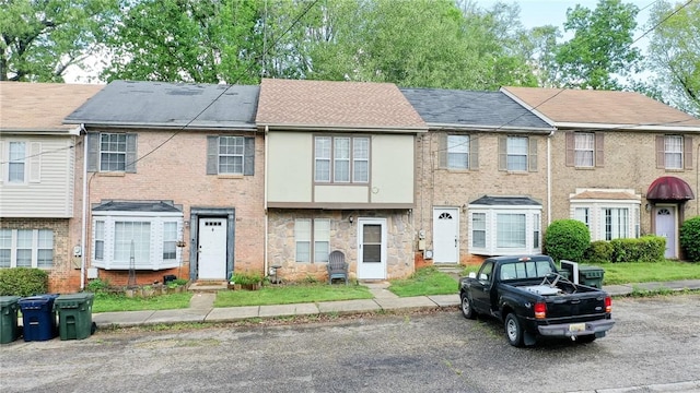 multi unit property with stone siding and a shingled roof