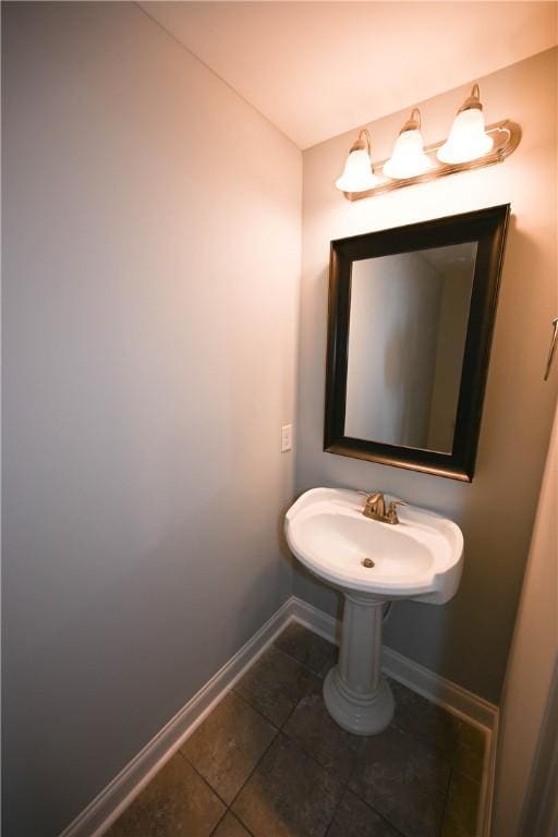 bathroom with baseboards, tile patterned flooring, and a sink