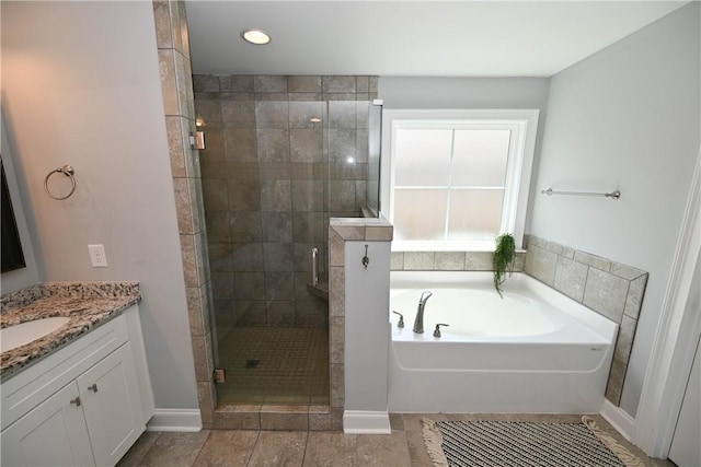 full bath featuring vanity, a stall shower, baseboards, and a garden tub