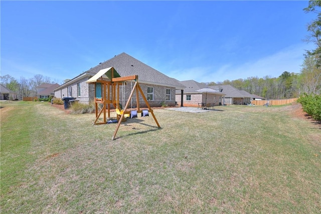 back of property featuring a playground and a lawn