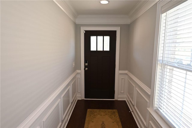 doorway to outside featuring crown molding, a decorative wall, and a healthy amount of sunlight