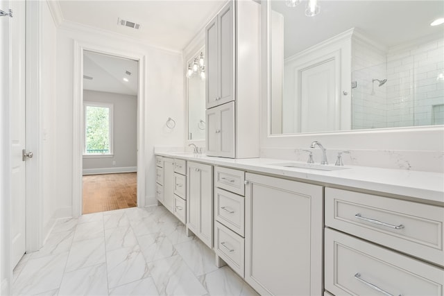 bathroom with a shower, vanity, and ornamental molding