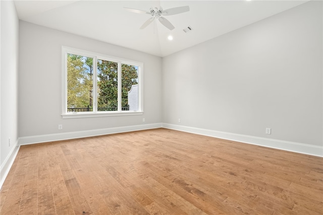 spare room featuring light wood-type flooring, ceiling fan, and lofted ceiling