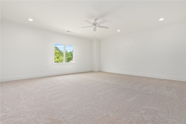 spare room featuring light carpet, crown molding, and ceiling fan