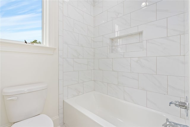 bathroom featuring tiled shower / bath combo and toilet