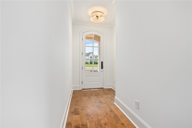 doorway with light wood-type flooring and crown molding