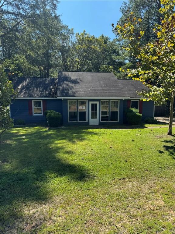 single story home featuring a front lawn