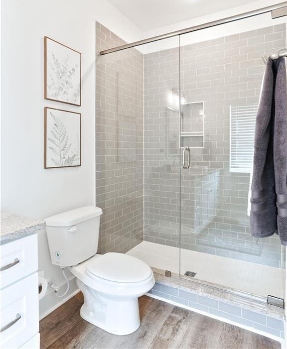 0103 Bradley Ln, Auburn, AL 36830 - full bath featuring wood finished floors, toilet, vanity, and a stall shower