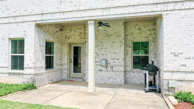 view of exterior entry with a patio area and ceiling fan