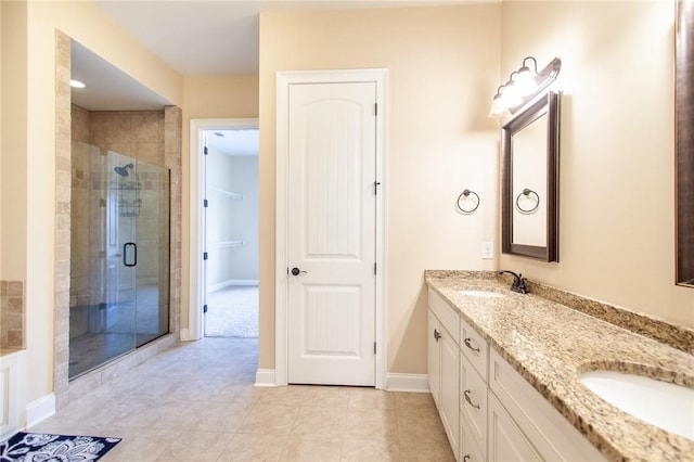 bathroom with tile patterned flooring, vanity, and a shower with door