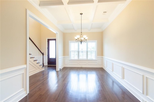 spare room with coffered ceiling, dark wood-type flooring, crown molding, beam ceiling, and an inviting chandelier