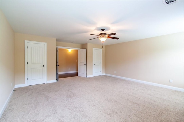 carpeted spare room with ceiling fan