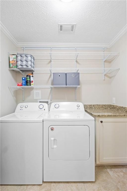 1016 E Magnolia Ave, Auburn, AL 36830 - laundry area featuring washing machine and clothes dryer, ornamental molding, a textured ceiling, and light tile patterned floors