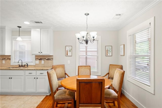 1016 E Magnolia Ave, Auburn, AL 36830 - dining area featuring a chandelier, ornamental molding, and light wood-style floors