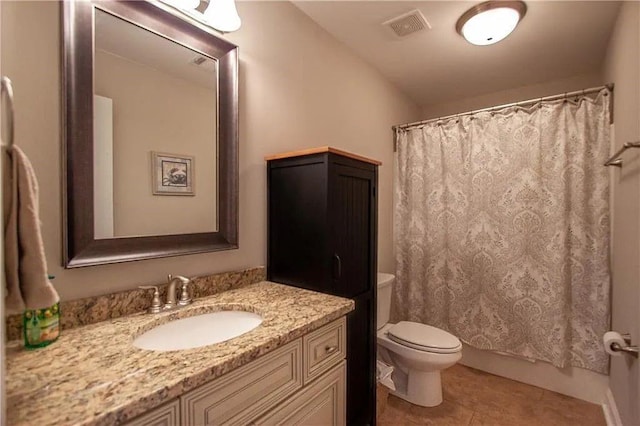 bathroom with tile patterned flooring, vanity, and toilet