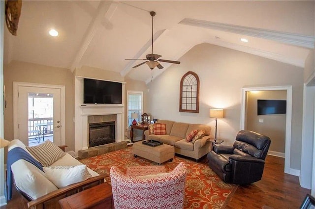 living room featuring a tiled fireplace, ceiling fan, hardwood / wood-style floors, and vaulted ceiling with beams