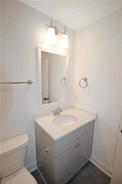 bathroom with toilet, tile patterned floors, and vanity