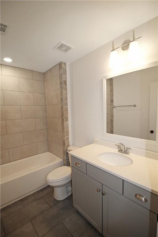 full bathroom with tiled shower / bath combo, toilet, tile patterned floors, and vanity