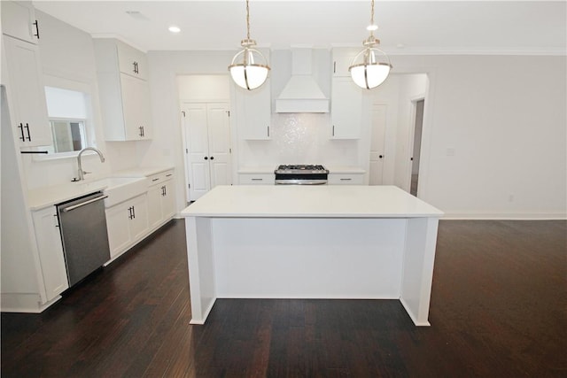 kitchen with a center island, decorative light fixtures, stainless steel appliances, premium range hood, and sink