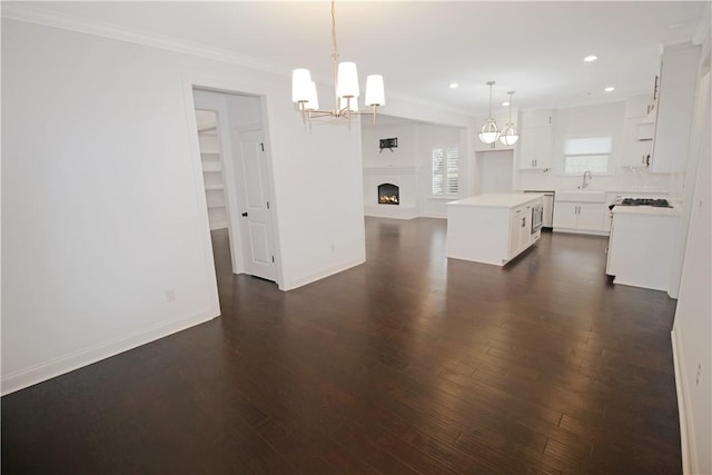 kitchen featuring pendant lighting, white cabinets, a center island, dark hardwood / wood-style flooring, and sink