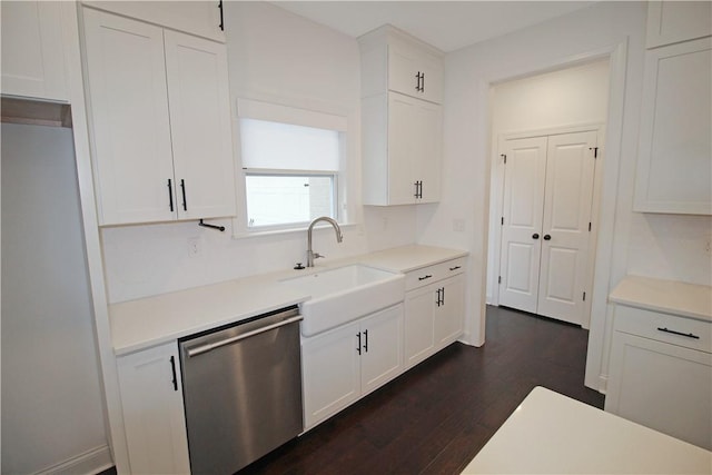 kitchen featuring dark wood-type flooring, white cabinets, stainless steel dishwasher, and sink