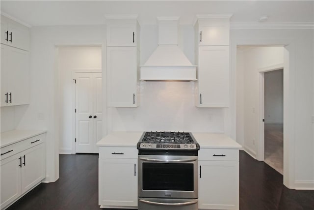 kitchen with gas stove, white cabinetry, premium range hood, dark hardwood / wood-style floors, and crown molding